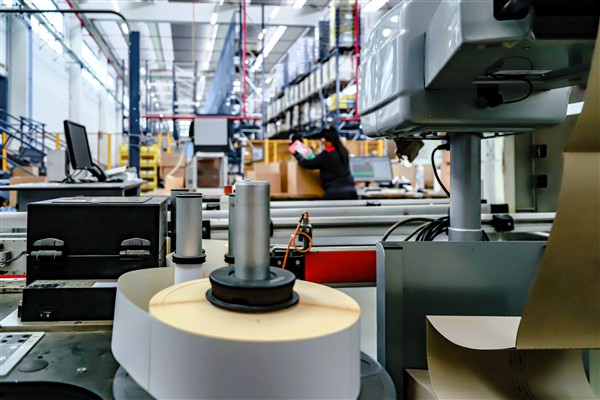 Close-up of automated labelling and verification equipment in a packaging line, showing precision application.